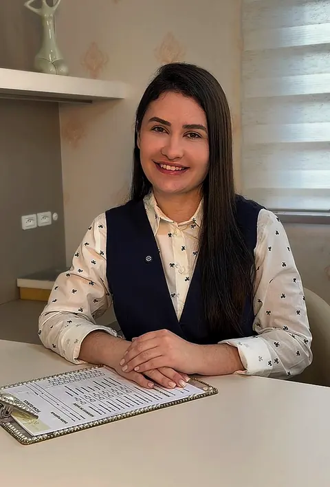 Profissional da Unna's sorrindo na mesa de avaliação, com a ficha da cliente